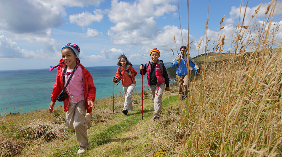 Parents and two children hiking across the coastline